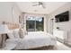 Bright main bedroom includes a TV, a large closet, and sliding glass door to the exterior patio at 11256 Rainbow Peak Ave # 202, Las Vegas, NV 89135