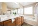 Bathroom featuring double sinks, wood cabinets, large mirror and separate shower and tub at 1180 Via Vinci, Henderson, NV 89052