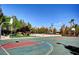 Outdoor basketball court amidst lush trees, with a water park and mountain views in the background at 151 Cliff Valley Dr, Las Vegas, NV 89148