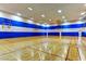 Indoor basketball court with wood floor, blue and white walls, and basketball hoops, for fun fitness activities at 151 Cliff Valley Dr, Las Vegas, NV 89148