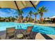 Inviting community pool area with lounge chairs under sunshades, palm trees and bright blue water at 151 Cliff Valley Dr, Las Vegas, NV 89148