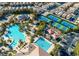 Aerial of community pools and tennis courts surrounded by palm trees and neighborhood residences at 151 Cliff Valley Dr, Las Vegas, NV 89148