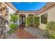 Charming home entrance with stone walkway, mature landscaping, and wrought iron security gate at 151 Cliff Valley Dr, Las Vegas, NV 89148