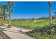 Scenic golf course view featuring lush green grass and swaying palm trees against a bright blue sky backdrop at 151 Cliff Valley Dr, Las Vegas, NV 89148