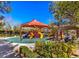 Community playground featuring colorful slides, climbing structures, and shaded seating areas surrounded by greenery at 151 Cliff Valley Dr, Las Vegas, NV 89148