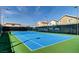 Bright blue tennis court surrounded by a tall fence and light posts provides a great recreational space at 151 Cliff Valley Dr, Las Vegas, NV 89148