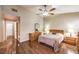Primary bedroom with wood laminate flooring, ceiling fan, and ensuite bathroom access at 1557 Lake Placid Ter # 1557, Henderson, NV 89014