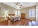 Primary bedroom with ceiling fan, wood laminate flooring, and large windows at 1557 Lake Placid Ter # 1557, Henderson, NV 89014