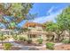 Charming multi-Gathering home featuring lush landscaping, mature trees, and a well-maintained walkway at 1557 Lake Placid Ter # 1557, Henderson, NV 89014