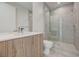 Modern bathroom featuring a large glass shower, gray tile, and light wood vanity at 1600 Pleasant Bay Ct, Henderson, NV 89011