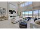 Bright living room boasts high ceilings, modern fireplace, and expansive windows with lake views at 1600 Pleasant Bay Ct, Henderson, NV 89011