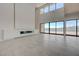 Bright living room features a modern fireplace, large windows with lake views, and tile floors at 1600 Pleasant Bay Ct, Henderson, NV 89011