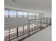Spacious loft area with large windows offering views and a sleek metal railing overlooking the lower level at 1600 Pleasant Bay Ct, Henderson, NV 89011