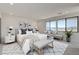 Bright bedroom with large windows, comfortable seating, and stylish decor overlooking the lake at 1600 Pleasant Bay Ct, Henderson, NV 89011