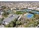 Stunning aerial view of the community amenities featuring tennis courts, a pool, and lush green spaces, all surrounded by residential homes at 1725 Cypress Manor Dr, Henderson, NV 89012