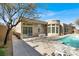 Luxury backyard featuring a pristine pool, covered patio, and beautiful desert landscaping at 1725 Cypress Manor Dr, Henderson, NV 89012