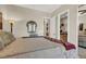 A well-lit bedroom features a plush bed, decorative wall mirror, and warm, inviting decor at 1725 Cypress Manor Dr, Henderson, NV 89012