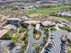Aerial view showcasing the grand clubhouse, manicured landscape, and ample parking at 1725 Cypress Manor Dr, Henderson, NV 89012