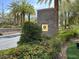 A community entrance with manicured landscaping, a stone sign, and mature trees at 1725 Cypress Manor Dr, Henderson, NV 89012