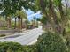 View of the community entrance, with palm trees, lush greenery, and a security gate at 1725 Cypress Manor Dr, Henderson, NV 89012