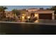Charming exterior view of a one-story home at dusk, featuring desert landscaping and a two-car garage at 1725 Cypress Manor Dr, Henderson, NV 89012