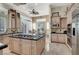 Bright kitchen featuring granite countertops, an island cooktop, stainless steel appliances, and a view of the dining area at 1725 Cypress Manor Dr, Henderson, NV 89012