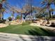 Beautifully landscaped area with rocks and synthetic grass, adorned with mature trees and shrubbery at 1725 Cypress Manor Dr, Henderson, NV 89012
