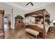 Main bedroom boasts wood flooring, four-poster bed, dresser, and a doorway to another room at 1725 Cypress Manor Dr, Henderson, NV 89012