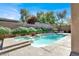 Beautiful pool with a spa and stone waterfall feature, surrounded by lush landscaping and a privacy wall at 1725 Cypress Manor Dr, Henderson, NV 89012