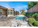 Beautiful backyard featuring pool, spa, covered patio, and lush landscaping at 1725 Cypress Manor Dr, Henderson, NV 89012