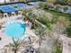 A stunning aerial shot of a circular pool and surrounding amenities, including tennis courts, landscaping, and shaded seating areas at 1725 Cypress Manor Dr, Henderson, NV 89012