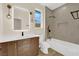 Modern bathroom features a wood vanity with white countertop, sleek fixtures, and a tiled shower-over-tub combo at 177 Rocky Star St, Henderson, NV 89012