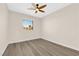 Bright bedroom features a ceiling fan and wood-look flooring with a view of the yard through the window at 177 Rocky Star St, Henderson, NV 89012