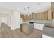 Modern kitchen with island, stainless steel appliances, two-tone cabinets, open to living area with wood-look floors at 177 Rocky Star St, Henderson, NV 89012