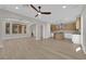 Open-concept living room with light wood floors, fan, and easy access to the kitchen and dining room at 177 Rocky Star St, Henderson, NV 89012