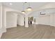 Expansive living room with modern lighting, wood-look floors, and archways leading to the kitchen and other spaces at 177 Rocky Star St, Henderson, NV 89012