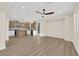 Open-concept living space with modern kitchen, island, and wood-look floors, illuminated by natural light and modern fixtures at 177 Rocky Star St, Henderson, NV 89012