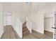 Inviting entryway featuring a staircase with white railings and wood-look floors, with an open door and tall ceilings at 177 Rocky Star St, Henderson, NV 89012