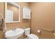 Half bath featuring a pedestal sink, matching toilet, and convenient built in storage cabinet at 2069 Colvin Run Dr, Henderson, NV 89052