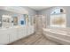 Bright bathroom featuring a large vanity, bathtub, and walk-in shower at 2069 Colvin Run Dr, Henderson, NV 89052