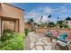 Charming backyard retreat featuring custom landscaping, rock pathway, mature palms and a fire pit at 2074 Sutton Way, Henderson, NV 89074