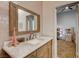Bathroom featuring light pink tiled walls and a wooden vanity with marble countertop, open to bedroom at 2074 Sutton Way, Henderson, NV 89074