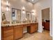 Bathroom featuring a double vanity with granite countertops, wooden cabinets, and decorative lighting fixtures at 2074 Sutton Way, Henderson, NV 89074