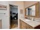 Bathroom featuring light pink tiled walls and a wooden vanity with marble countertop, open to living space at 2074 Sutton Way, Henderson, NV 89074