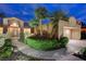 Night view of a home with mature trees, desert landscaping and exterior lighting at 2074 Sutton Way, Henderson, NV 89074