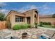 Well maintained front yard featuring desert landscaping, mature trees, and unique stonework at 2074 Sutton Way, Henderson, NV 89074