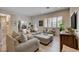 Inviting living room with neutral tones, plush seating, natural light and wood laminate flooring at 2074 Sutton Way, Henderson, NV 89074