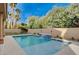 Private backyard oasis features a sparkling pool with a decorative water feature, surrounded by lush greenery and blue skies at 2074 Sutton Way, Henderson, NV 89074