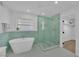 Bathroom featuring freestanding tub, glass shower with green tiling, and modern finishes at 2160 Pueblo Cir, Las Vegas, NV 89169