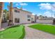 Modern home exterior with a putting green, decorative rock, palm trees, and a well-manicured yard at 2160 Pueblo Cir, Las Vegas, NV 89169